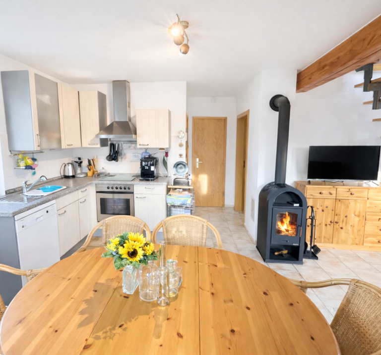 Ferienhaus Bodden & Ostsee, Voll ausgestattete Küche, Sitzmöglichkeiten, Kamin, Esstisch für sechs Personen